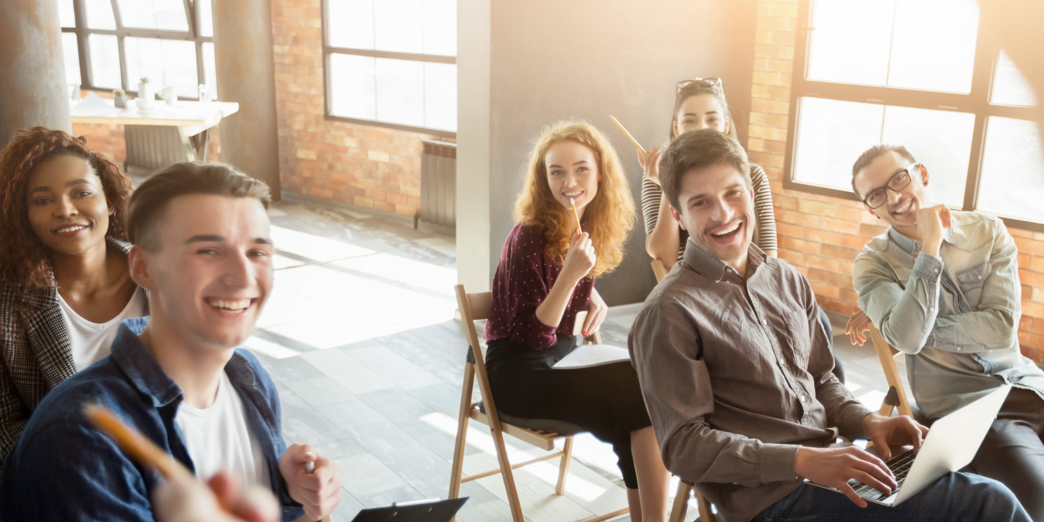Fünf Menschen sitzen ein einem Raum und blicken auf eine vortragende Person