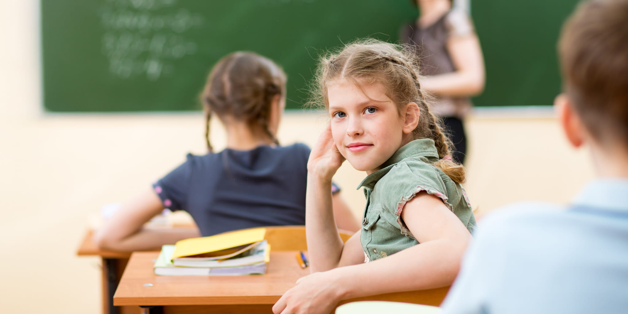 Mädchen sitzt in einem Klassenraum und schaut zurück