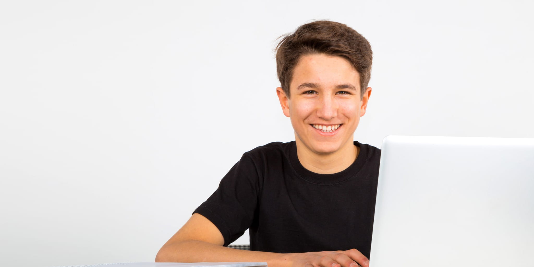 Junge sitzt an einem Laptop