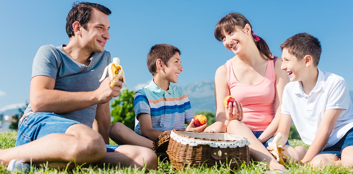 Eltern machen Picknick mit ihren beiden Kindern