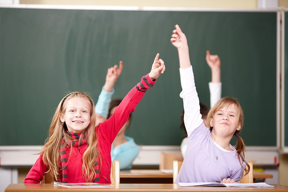 Kinder melden sich im Unterricht